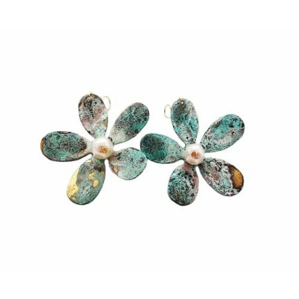 Μεγάλα εντυπωσιακά σκουλαρίκια κρεμαστά με πέρλες - 3005, Μεγάλα εντυπωσιακά κρεμαστά σκουλαρίκια με πέρλες που συνδυάζουν το boho στιλ με τη σύγχρονη αισθητική. Αυτά τα μοναδικά χειροποίητα γυναικεία σκουλαρίκια λουλούδια, σχεδιασμένα από την Ελληνίδα Σχεδιάστρια Κοσμημάτων Αικατερίνη Χαλκιαδάκη, ξεχωρίζουν για τη μοντέρνα patina επίστρωση που δημιουργεί εντυπωσιακούς πράσινους τόνους με χρυσαφένιες πινελιές.
Κάθε σκουλαρίκι διαμορφώνεται σε σχήμα μαργαρίτας με έξι οβάλ πέταλα από οξειδωμένο ορείχαλκο, ενώ στο κέντρο φιλοξενεί μία φυσική πέρλα που προσδίδει κομψότητα και φως. Η τεχνική του οξειδωμένου χαλκού δίνει μοναδικούς χρωματισμούς που κάνουν κάθε κόσμημα ξεχωριστό. Το μέγεθός τους καθιστά αυτά τα εντυπωσιακά σκουλαρίκια για γάμο ή ειδικές περιστάσεις την ιδανική επιλογή.
Ιδανικά για να συνδυαστούν με boho ντυσίματα ή να προσθέσουν χρώμα σε μονόχρωμα outfits.