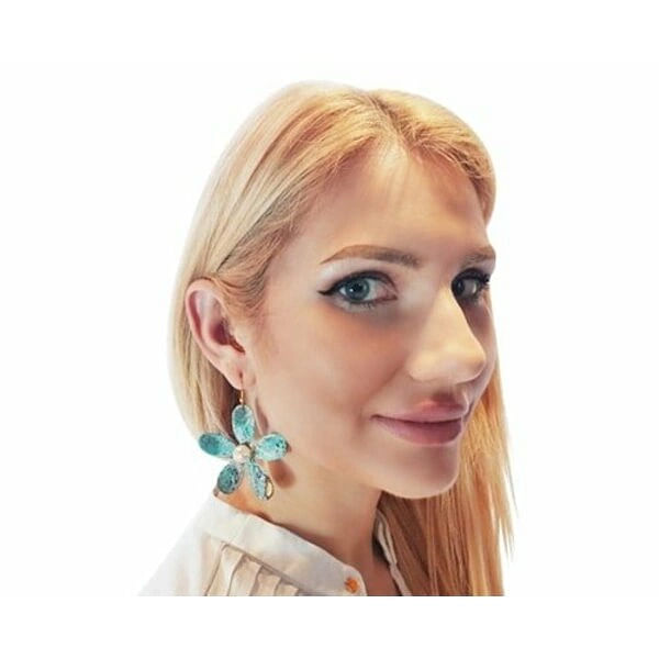 Μεγάλα εντυπωσιακά σκουλαρίκια κρεμαστά με πέρλες - 3005, Μεγάλα εντυπωσιακά κρεμαστά σκουλαρίκια με πέρλες που συνδυάζουν το boho στιλ με τη σύγχρονη αισθητική. Αυτά τα μοναδικά χειροποίητα γυναικεία σκουλαρίκια λουλούδια, σχεδιασμένα από την Ελληνίδα Σχεδιάστρια Κοσμημάτων Αικατερίνη Χαλκιαδάκη, ξεχωρίζουν για τη μοντέρνα patina επίστρωση που δημιουργεί εντυπωσιακούς πράσινους τόνους με χρυσαφένιες πινελιές.
Κάθε σκουλαρίκι διαμορφώνεται σε σχήμα μαργαρίτας με έξι οβάλ πέταλα από οξειδωμένο ορείχαλκο, ενώ στο κέντρο φιλοξενεί μία φυσική πέρλα που προσδίδει κομψότητα και φως. Η τεχνική του οξειδωμένου χαλκού δίνει μοναδικούς χρωματισμούς που κάνουν κάθε κόσμημα ξεχωριστό. Το μέγεθός τους καθιστά αυτά τα εντυπωσιακά σκουλαρίκια για γάμο ή ειδικές περιστάσεις την ιδανική επιλογή.
Ιδανικά για να συνδυαστούν με boho ντυσίματα ή να προσθέσουν χρώμα σε μονόχρωμα outfits.