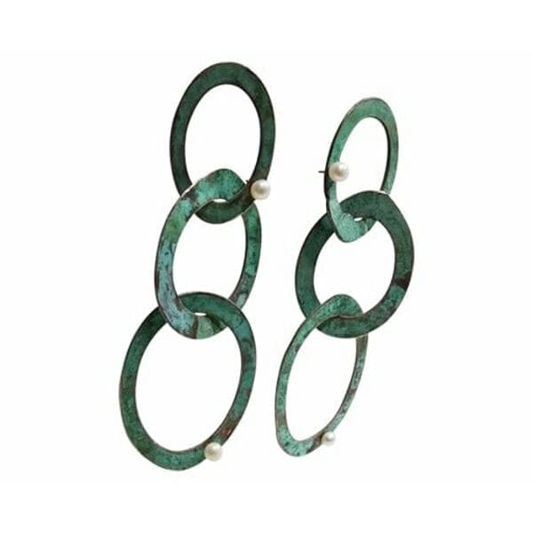 Μεγάλα εντυπωσιακά σκουλαρίκια μακριά καρφωτά με μαργαριτάρια - 3731, Ανακαλύψτε τη μαγεία των μεγάλων εντυπωσιακών σκουλαρικιών που συνδυάζουν την κομψότητα του χαλκού με την πράσινη πατίνα σε ένα μοναδικό design. Αυτά τα χειροποίητα μακριά καρφωτά σκουλαρίκια, σχεδιασμένα από την Ελληνίδα Σχεδιάστρια Κοσμημάτων Αικατερίνη Χαλκιαδάκη, δημιουργούν statement look που προσελκύει τα βλέμματα.
Το innovative design με τους αλληλένδετους κρίκους σε πράσινη πατίνα δίνει bohemian αισθητική που ταιριάζει τέλεια σε σύγχρονες γυναίκες. Κάθε κρίκος είναι χειροτεχνημένος από υψηλής ποιότητας χαλκό και διακοσμημένος με φυσικά μαργαριτάρια που προσθέτουν λάμψη και κομψότητα. Η μοναδική πράσινη πατίνα δημιουργεί vintage αίσθηση που συνδυάζεται άψογα με μοντέρνα και κλασικά outfits.
Τα κρεμαστά σκουλαρίκια αυτά είναι ιδανικά για ιδιαίτερες στιγμές, νυφικές εμφανίσεις ή everyday chic looks. Η ελληνική τεχνογνωσία φαίνεται σε κάθε λεπτομέρεια, από την τέλεια ισορροπία των κρίκων μέχρι την προσεκτική τοποθέτηση των περλών. Φυλάξτε τα σε στεγνό μέρος και καθαρίστε τα απαλά με μαλακό πανί.