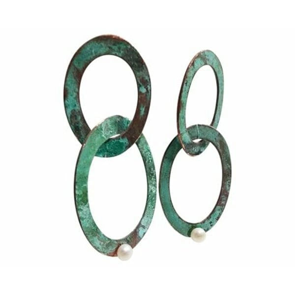 Μεγάλα εντυπωσιακά σκουλαρίκια μακριά με μαργαριτάρια και χρώμα - 3732, Αναδείξτε τη μοναδική σας προσωπικότητα με αυτά τα εντυπωσιακά μεγάλα σκουλαρίκια κρεμαστά που συνδυάζουν την κομψότητα των μαργαριταριών με τη μοντέρνα αισθητική του χαλκού. Σχεδιασμένα από την Ελληνίδα Σχεδιάστρια Κοσμημάτων Αικατερίνη Χαλκιαδάκη, αυτά τα χειροποίητα σκουλαρίκια φέρουν την υπογραφή της γνήσιας ελληνικής τέχνης κοσμηματοποιίας.
Η μοναδική πράσινη πατίνα που καλύπτει τους διπλούς κρίκους δημιουργεί ένα vintage αποτέλεσμα που συναρπάζει, ενώ οι φυσικές πέρλες προσθέτουν μια πινελιά κομψότητας και λάμψης. Κάθε κομμάτι είναι μοναδικό, καθώς η πατίνα αναπτύσσεται φυσικά στον χαλκό, δημιουργώντας ανεπανάληπτες αποχρώσεις και υφές.
Τα μακριά αυτά σκουλαρίκια είναι ιδανικά για ιδιαίτερες εμφανίσεις, γάμους, βραδινές εξόδους ή όταν θέλετε να προσθέσετε μια boho πινελιά στο καθημερινό σας στυλ. Το ιδιαίτερο σχήμα των διπλών κρίκων δημιουργεί όμορφες κινήσεις και αντανακλάσεις φωτός.
