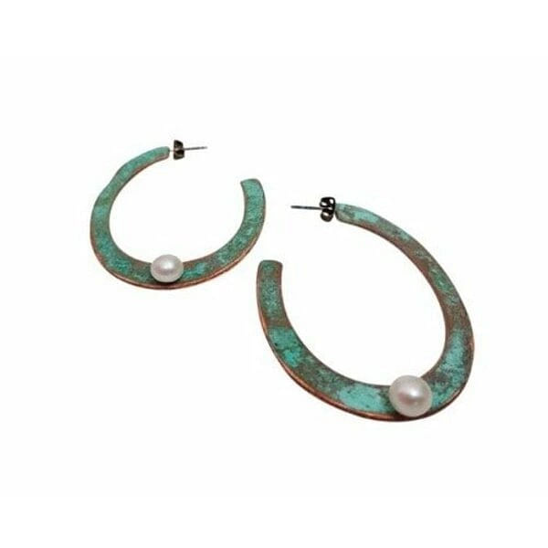 Μεγάλα σκουλαρίκια κρίκοι καρφωτά με μαργαριτάρια - 3775, Εντυπωσιακά σκουλαρίκια κρίκοι με μαργαριτάρια που συνδυάζουν τη φυσική ομορφιά του χαλκού με την κομψότητα των πέρλων. Αυτά τα μεγάλα καρφωτά σκουλαρίκια, σχεδιασμένα από την Ελληνίδα Σχεδιάστρια Κοσμημάτων Αικατερίνη Χαλκιαδάκη, διαθέτουν μοναδική πράσινη πατίνα που προσδίδει vintage χαρακτήρα και αυθεντικότητα.
Κάθε σκουλαρίκι φέρει μία λευκή πέρλα τοποθετημένη στρατηγικά στο κάτω μέρος του κρίκου, δημιουργώντας ένα τέλειο contrast με την οξειδωμένη επιφάνεια του χαλκού. Η χειροποίητη κατασκευή και η φυσική πατίνα καθιστούν κάθε ζεύγος μοναδικό, ενώ ο ανοιχτός σχεδιασμός του κρίκου προσφέρει άνεση και στυλ.
Ιδανικά για γυναίκες που αγαπούν τα statement κοσμήματα με boho στοιχεία, αυτά τα σκουλαρίκια ολοκληρώνουν τόσο casual όσο και επίσημα looks. Η κλασική φόρμα του κρίκου σε συνδυασμό με την πέρλα τα καθιστά κατάλληλα για γάμους, ειδικές περιστάσεις και καθημερινή χρήση.
