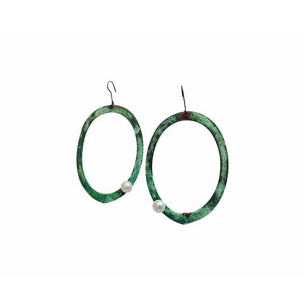 Εντυπωσιακά κρεμαστά σκουλαρίκια κρίκοι με μαργαριτάρια που συνδυάζουν τη φυσική ομορφιά των πέρλων με την αυθεντική ελληνική τέχνη. Σχεδιασμένα από την Ελληνίδα Σχεδιάστρια Κοσμημάτων Αικατερίνη Χαλκιαδάκη, αυτά τα μοναδικά χειροποίητα σκουλαρίκια αποτελούν την τέλεια επιλογή για τη γυναίκα που αναζητά πρωτότυπα κοσμήματα με χαρακτήρα.\u000AΗ πράσινη πατίνα που καλύπτει το χαλκό δημιουργεί μια vintage αισθητική που ταιριάζει τόσο σε καθημερινά όσο και σε επίσημα look. Οι λευκές πέρλες προσθέτουν κομψότητα και φωτεινότητα, δημιουργώντας έναν τέλειο συνδυασμό που τονίζει τη φυσική ομορφιά του προσώπου. Η ιδιαίτερη επεξεργασία του χαλκού δίνει σε κάθε κόσμημα μοναδικό χαρακτήρα.\u000AΑυτά τα μοντέρνα κρεμαστά σκουλαρίκια είναι ιδανικά για γάμο, βραδινές εξόδους ή όταν θέλετε να προσθέσετε μια δόση bohemian κομψότητας στην καθημερινότητά σας. Φυλάξτε σε στεγνό μέρος και καθαρίστε απαλά με μαλακό πανί για να διατηρήσετε τη λάμψη των μαργαριταριών και την πατίνα του χαλκού.