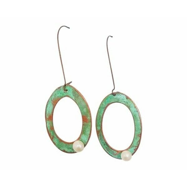 Ανακαλύψτε τη μαγεία των μεγάλων κρεμαστών σκουλαρικιών κρίκων με μαργαριτάρια που συνδυάζουν τη vintage αισθητική με τη σύγχρονη κομψότητα. Κάθε κομμάτι είναι χειροποίητο και σχεδιασμένο από την Ελληνίδα Σχεδιάστρια Κοσμημάτων Αικατερίνη Χαλκιαδάκη, προσφέροντας μια μοναδική πρόταση στυλ.\u000AΤα εντυπωσιακά αυτά σκουλαρίκια διακρίνονται από τους οβάλ χάλκινους κρίκους με την πανέμορφη πράσινη πατίνα που δημιουργεί έναν vintage χαρακτήρα. Κάθε κρίκος φέρει μία λευκή πέρλα που προσθέτει κομψότητα και φωτεινότητα στο σχέδιο. Η αντίθεση μεταξύ του ζεστού χαλκού και των λευκών μαργαριταριών δημιουργεί έναν εξαιρετικό συνδυασμό χρωμάτων.\u000AΤα μακριά κρεμαστά σκουλαρίκια είναι ιδανικά για γάμους, βραδινές εξόδους ή κάθε στιγμή που θέλετε να ξεχωρίσετε. Η ελαφριά κατασκευή τους εξασφαλίζει άνετη χρήση όλη την ημέρα. Φυλάσσετε σε στεγνό μέρος και καθαρίζετε απαλά με μαλακό πανί.