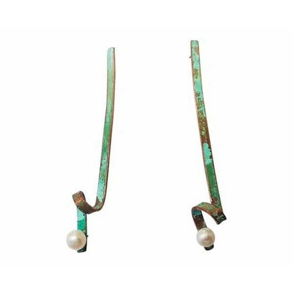 Ξεχωρίστε με αυτά τα μεγάλα εντυπωσιακά σκουλαρίκια καρφωτά με μαργαριτάρια που συνδυάζουν την κομψότητα των πέρλων με τη μοναδική αισθητική της πράσινης πατίνας. Κάθε κόσμημα είναι σχεδιασμένο από την Ελληνίδα Σχεδιάστρια Κοσμημάτων Αικατερίνη Χαλκιαδάκη και δημιουργείται εξ ολοκλήρου στο χέρι με προσοχή στη λεπτομέρεια.\u000AΤα χειροποίητα σκουλαρίκια διαθέτουν μακρύ γεωμετρικό σχήμα από χαλκό με φυσική πράσινη πατίνα που δημιουργεί μοναδικές χρωματικές αποχρώσεις. Κάθε σκουλαρίκι ολοκληρώνεται με μία λευκή πέρλα που προσθέτει κλασική κομψότητα και φωτεινότητα στο σχέδιο. Το καρφωτό κλείσιμο εξασφαλίζει άνετη και ασφαλή εφαρμογή για όλη την ημέρα.\u000AΑυτά τα εντυπωσιακά μακριά σκουλαρίκια είναι ιδανικά για ιδιαίτερες περιστάσεις, γάμους ή όταν θέλετε να δώσετε μία μοντέρνα πινελιά στην εμφάνισή σας. Συνδυάζονται τέλεια με μονόχρωμα outfits και προσδίδουν μοναδικό στυλ.