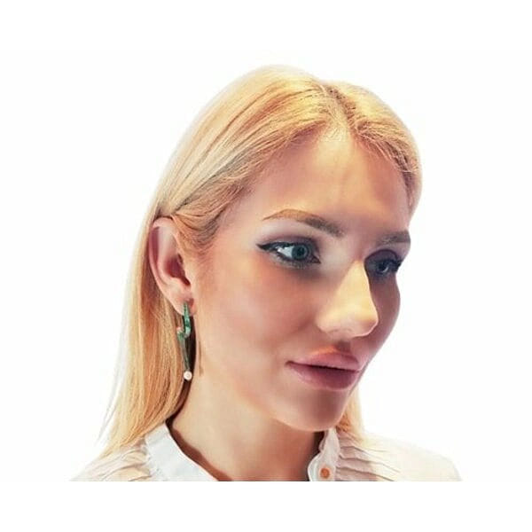 Σκουλαρίκια καρφωτά κοντά με μαργαριτάρια και χρώμα - 3976, Αυτά τα εντυπωσιακά χειροποίητα σκουλαρίκια καρφωτά με μαργαριτάρια συνδυάζουν την κλασική κομψότητα με τη σύγχρονη αισθητική. Σχεδιασμένα από την Ελληνίδα Σχεδιάστρια Κοσμημάτων Αικατερίνη Χαλκιαδάκη, αποτελούν έναν ιδανικό συνδυασμό τέχνης και στυλ που ανανεώνει κάθε εμφάνιση.
Η μοναδική geometric σιλουέτα με την πράσινη πατίνα δημιουργεί μια vintage αισθητική που ξεχωρίζει, ενώ οι λευκές πέρλες στο κάτω μέρος προσδίδουν κλασική χάρη. Ο χαλκός έχει υποστεί ειδική επεξεργασία που δημιουργεί τον χαρακτηριστικό πράσινο χρωματισμό, δίνοντας σε κάθε κόσμημα μια ξεχωριστή προσωπικότητα.
Αυτά τα κρεμαστά σκουλαρίκια είναι ιδανικά για γυναίκες που αγαπούν τα statement κοσμήματα με χαρακτήρα. Η εργονομική τους σχεδίαση εξασφαλίζει άνεση καθ' όλη τη διάρκεια της ημέρας, ενώ η ποιότητα κατασκευής εγγυάται αντοχή και διάρκεια.