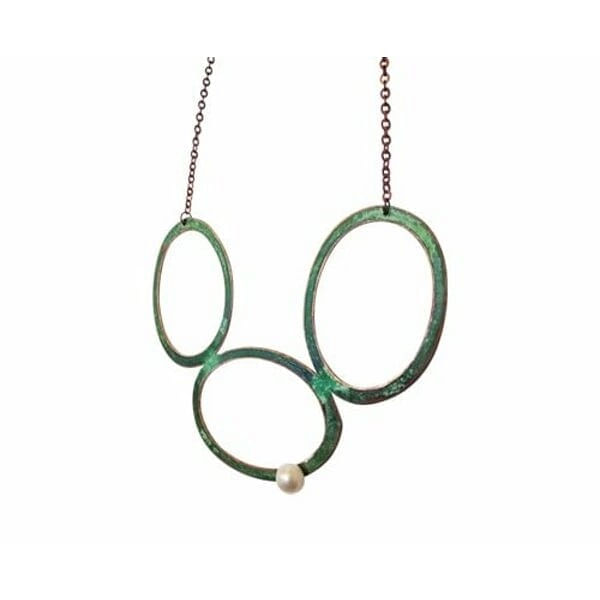 Μεγάλο γυναικείο κολιέ με μαργαριτάρι και χρώμα - 3046, Ενα εντυπωσιακό μεγάλο γυναικείο κολιέ με μαργαριτάρι που συνδυάζει τη μοναδικότητα του χειροποίητου σχεδιασμού με την κομψότητα του οξειδωμένου χαλκού. Αυτό το statement κολιέ, σχεδιασμένο από την Αικατερίνη Χαλκιαδάκη, αποτελεί τη τέλεια επιλογή για γυναίκες που αναζητούν ένα ιδιαίτερο κόσμημα που θα τραβά τα βλέμματα.
Το μακρύ κολιέ διαθέτει τρεις μεγάλους κυκλικούς κρίκους από χαλκό με πράσινο patina φινίρισμα που δημιουργεί μια vintage αισθητική. Ένα φυσικό μαργαριτάρι κοσμεί έναν από τους κρίκους, προσθέτοντας λάμψη και κομψότητα στο σύνολο. Η μοναδική εμφάνιση του οξειδωμένου χαλκού καθιστά κάθε κολιέ μοναδικό, καθώς το patina αναπτύσσεται φυσικά με τον χρόνο.
Ιδανικό για layering με άλλα κοσμήματα ή ως αυτοτελές statement piece, αυτό το εντυπωσιακό κολιέ προσθέτει μια καλλιτεχνική πινελιά σε κάθε outfit. Η χειροποίητη κατασκευή εγγυάται την ποιότητα και τη μοναδικότητα του ελληνικού κοσμήματος.