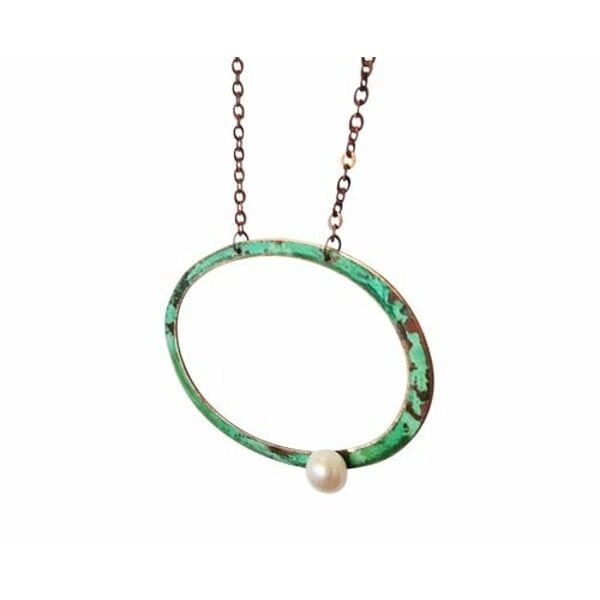 Μεγάλο γυναικείο κολιέ με μαργαριτάρι και χρώμα - 3044, Ανακαλύψτε την τέλεια ισορροπία μεταξύ σύγχρονου design και κλασικής κομψότητας με αυτό το μεγάλο γυναικείο κολιέ με μαργαριτάρι. Σχεδιασμένο από την Ελληνίδα Σχεδιάστρια Κοσμημάτων Αικατερίνη Χαλκιαδάκη, αυτό το χειροποίητο κόσμημα συνδυάζει την ομορφιά του οξειδωμένου χαλκού με την κομψότητα της φρέσκιας πέρλας.
Το γεωμετρικό σχήμα του κύκλου δημιουργεί ένα statement look που προσελκύει τα βλέμματα, ενώ οι αποχρώσεις του πράσινου χαλκού προσδίδουν έναν μοναδικό vintage χαρακτήρα. Η λευκή πέρλα στη βάση του κολιέ προσφέρει την τέλεια αντίθεση, δημιουργώντας ένα εντυπωσιακό αποτέλεσμα που συνδυάζεται εύκολα με κάθε outfit.
Ιδανικό για τις γυναίκες που αγαπούν τα μεγάλα εντυπωσιακά κολιέ και αναζητούν κοσμήματα με προσωπικότητα. Φοριέται εξίσου όμορφα με casual ή πιο επίσημα looks, προσφέροντας άπειρες δυνατότητες styling. Αποθηκεύετε σε στεγνό μέρος και καθαρίζετε απαλά με μαλακό πανί για να διατηρήσετε τη φυσική οξείδωση του χαλκού.