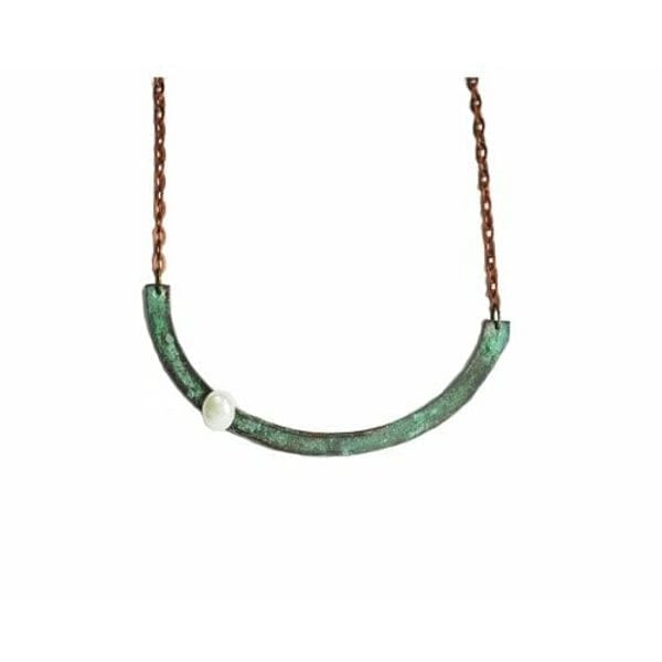 Γυναικείο κολιέ με μαργαριτάρι και χρώμα - 3043, Ανακαλύψτε τη μαγεία του χειροποίητου κοσμήματος με αυτό το εντυπωσιακό γυναικείο κολιέ σε σχήμα ημικύκλιου, σχεδιασμένο από την Ελληνίδα Σχεδιάστρια Κοσμημάτων Αικατερίνη Χαλκιαδάκη. Το μοναδικό αυτό statement κολιέ συνδυάζει τον οξειδωμένο χαλκό σε πράσινες αποχρώσεις με την κλασική κομψότητα του λευκού μαργαριταριού, δημιουργώντας ένα κόσμημα που ξεχωρίζει.
Η ημικυκλική σιλουέτα προσφέρει μοντέρνο στιλ και γεωμετρική αισθητική, ενώ το φυσικό patina του χαλκού σε πράσινες αποχρώσεις δίνει χαρακτήρα και αυθεντικότητα. Το λευκό μαργαριτάρι που διακοσμεί το κολιέ προσθέτει μια νότα κλασικής κομψότητας, δημιουργώντας την τέλεια αντίθεση με το οξειδωμένο μέταλλο.
Ιδανικό για layering με άλλα κολιέ ή ως αυτόνομο statement piece, αυτό το χειροποίητο κόσμημα μεταμορφώνει κάθε εμφάνιση από casual σε sophisticated. Η ανατομική του φόρμα εφαρμόζει άνετα στον λαιμό, ενώ η χάλκινη αλυσίδα εξασφαλίζει άνεση και στιλ.