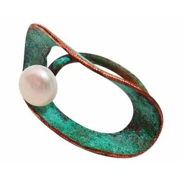 Ανακαλύψτε την μαγεία του εντυπωσιακού δαχτυλιδιού που συνδυάζει την αισθητική της πατίνας με την κομψότητα του μαργαριταριού. Αυτό το μεγάλο χειροποίητο δαχτυλίδι, σχεδιασμένο από την Αικατερίνη Χαλκιαδάκη, αποτελεί ένα μοναδικό κόσμημα που ξεχωρίζει με την ασυμμετρική του φόρμα και τις εκφραστικές του γραμμές.\u000AΤο δαχτυλίδι κατασκευάζεται από χαλκό με εξαιρετική πράσινη πατίνα που δημιουργεί μια vintage αισθητική γεμάτη χαρακτήρα. Η φυσική πέρλα που τοποθετείται στρατηγικά στη σύνθεση προσδίδει αντίθεση και λάμψη, δημιουργώντας έναν τέλειο συνδυασμό παραδοσιακής τεχνικής με σύγχρονο design. Η ασυμμετρική γεωμετρική φόρμα του δαχτυλιδιού το καθιστά ιδανικό για γυναίκες που αναζητούν statement κοσμήματα με καλλιτεχνικό χαρακτήρα.