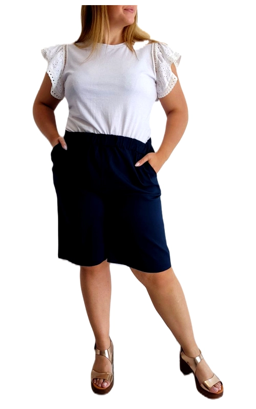 Κομψή βερμούδα σε βαθύ blue navy, σχεδιασμένη ειδικά για γυναίκες με καμπύλες που αναζητούν άνεση και στυλ. Διαθέτει φαρδιά γραμμή με λάστιχο στη μέση και πρακτικές τσέπες στο πλάι, προσφέροντας άψογη εφαρμογή και ελευθερία κινήσεων. Το μήκος της φτάνει λίγο πάνω από το γόνατο, χαρίζοντας κολακευτική εμφάνιση στα πόδια. Συνδυάζεται υπέροχα με το λευκό μπλουζάκι με τα διακοσμητικά δαντελωτά μανίκια που φαίνεται στην εικόνα, δημιουργώντας ένα κομψό σύνολο για καθημερινές εμφανίσεις. Ιδανική για καλοκαιρινές βόλτες, ψώνια ή χαλαρά απογευματινά με φίλους. Το ανάλαφρο ύφασμα εξασφαλίζει δροσερή αίσθηση ακόμα και τις πιο ζεστές μέρες, ενώ η απλή κομψή γραμμή της την καθιστά βασικό κομμάτι για αμέτρητους συνδυασμούς. Φορέστε την με πέδιλα, σανδάλια ή αθλητικά παπούτσια για διαφορετικά στυλ που ταιριάζουν σε κάθε περίσταση.
