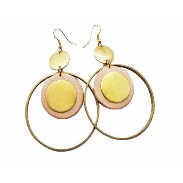 Ανακαλύψτε τη μαγεία των μεγάλων κρεμαστών σκουλαρικιών κρίκων με ξύλο που συνδυάζουν την φυσική ομορφιά με το σύγχρονο design. Αυτό το εντυπωσιακό χειροποίητο κόσμημα, σχεδιασμένο από την Ελληνίδα Σχεδιάστρια Κοσμημάτων Αικατερίνη Χαλκιαδάκη, αποτελεί την τέλεια επιλογή για γυναίκες που αγαπούν τα statement accessories.\u000AΤα σκουλαρίκια χαρακτηρίζονται από την μοναδική τους γεωμετρική σύνθεση που περιλαμβάνει χρυσούς κρίκους από ορείχαλκο και φυσικά ξύλινα στοιχεία σε απαλούς τόνους ροζ και κίτρινου. Η ιδιαίτερη διάταξη των στοιχείων δημιουργεί ένα εκλεπτυσμένο boho look που συνδυάζει άψογα με κάθε ντύσιμο.\u000AΚάθε ζευγάρι κατασκευάζεται με προσοχή χρησιμοποιώντας αποκλειστικά φυσικά υλικά υψηλής ποιότητας. Το ξύλο επεξεργάζεται ειδικά για να αποκτήσει την μοναδική του υφή και χρωματισμό, ενώ τα μεταλλικά μέρη από ορείχαλκο προσφέρουν ανθεκτικότητα και λάμψη.