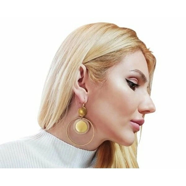 Μεγάλα σκουλαρίκια κρίκοι κρεμαστά με ξύλο - 2987, Ανακαλύψτε τη μαγεία των μεγάλων κρεμαστών σκουλαρικιών κρίκων με ξύλο που συνδυάζουν την φυσική ομορφιά με το σύγχρονο design. Αυτό το εντυπωσιακό χειροποίητο κόσμημα, σχεδιασμένο από την Ελληνίδα Σχεδιάστρια Κοσμημάτων Αικατερίνη Χαλκιαδάκη, αποτελεί την τέλεια επιλογή για γυναίκες που αγαπούν τα statement accessories.
Τα σκουλαρίκια χαρακτηρίζονται από την μοναδική τους γεωμετρική σύνθεση που περιλαμβάνει χρυσούς κρίκους από ορείχαλκο και φυσικά ξύλινα στοιχεία σε απαλούς τόνους ροζ και κίτρινου. Η ιδιαίτερη διάταξη των στοιχείων δημιουργεί ένα εκλεπτυσμένο boho look που συνδυάζει άψογα με κάθε ντύσιμο.
Κάθε ζευγάρι κατασκευάζεται με προσοχή χρησιμοποιώντας αποκλειστικά φυσικά υλικά υψηλής ποιότητας. Το ξύλο επεξεργάζεται ειδικά για να αποκτήσει την μοναδική του υφή και χρωματισμό, ενώ τα μεταλλικά μέρη από ορείχαλκο προσφέρουν ανθεκτικότητα και λάμψη.