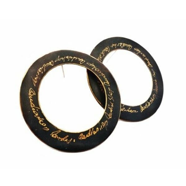 Ανακαλύψτε τη μαγεία των χειρόγραφων κρίκων που μεταμορφώνουν κάθε εμφάνισή σας σε έργο τέχνης. Αυτά τα εντυπωσιακά μεγάλα σκουλαρίκια κρίκοι καρφωτά, σχεδιασμένα από την Ελληνίδα Σχεδιάστρια Κοσμημάτων Αικατερίνη Χαλκιαδάκη, φέρουν χειρόγραφες λεπτομέρειες που δημιουργούν μια μοναδική αισθητική.\u000AΚατασκευασμένα από ποιοτικό ορείχαλκο με εκλεκτή μαύρη πατίνα, αυτά τα χειροποίητα καρφωτά σκουλαρίκια συνδυάζουν την κλασική κομψότητα του κρίκου με την πρωτοτυπία του χειρόγραφου στοιχείου. Η μαύρη απόχρωση προσδίδει έντονο χαρακτήρα και versatility, καθιστώντας τα ιδανικά για καθημερινές εμφανίσεις αλλά και ειδικές περιστάσεις.\u000AΤα μοντέρνα σκουλαρίκια αυτά αποτελούν την τέλεια επιλογή για γυναίκες που αγαπούν τα statement κοσμήματα και αναζητούν κάτι διαφορετικό. Η χειροποίητη κατασκευή εγγυάται την μοναδικότητα κάθε τεμαχίου, ενώ το καρφωτό σύστημα προσφέρει άνεση και ασφάλεια.