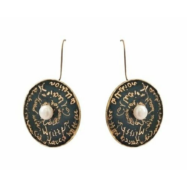 Χειρόγραφα σκουλαρίκια μακριά κρεμαστά με μαργαριτάρια - 4679, Τα χειρόγραφα σκουλαρίκια κρεμαστά με μαργαριτάρια αποτελούν μια εκλεπτυσμένη επιλογή για τη γυναίκα που αναζητά μοναδικότητα και στυλ. Σχεδιασμένα από την Ελληνίδα Σχεδιάστρια Κοσμημάτων Αικατερίνη Χαλκιαδάκη, αυτά τα εντυπωσιακά χειροποίητα κοσμήματα συνδυάζουν την κλασική ομορφιά των μαργαριταριών με τη σύγχρονη αισθητική.
Κατασκευασμένα από ποιοτικό ορείχαλκο με μαύρη πατίνα, τα σκουλαρίκια διαθέτουν κυκλικό σχήμα με χαραγμένα χειρόγραφα κείμενα που δημιουργούν έναν artistic χαρακτήρα. Το κεντρικό λευκό μαργαριτάρι σε κάθε κομμάτι προσθέτει λάμψη και κομψότητα, ενώ το χρυσαφί φινίρισμα συμπληρώνει αρμονικά τη συνολική εμφάνιση.
Αυτά τα μακριά κρεμαστά σκουλαρίκια είναι ιδανικά για εκδηλώσεις, γάμους ή καθημερινή εμφάνιση που θέλετε να ξεχωρίσει. Η χειροποίητη κατασκευή εγγυάται τη μοναδικότητα κάθε κομματιού.
