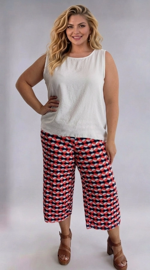 Η γυναικεία ζιπ κιλότ plus size είναι η ιδανική επιλογή για μια φρέσκια και μοντέρνα εμφάνιση. Διαθέτει ένα εντυπωσιακό γεωμετρικό μοτίβο σε συνδυασμό χρωμάτων κοραλί, σκούρο ναυτικό μπλε και εκρού, που δημιουργεί ένα παιχνιδιάρικο και ζωντανό αποτέλεσμα. Το σχέδιο αποτελείται από κυκλικά και οβάλ σχήματα που εναλλάσσονται αρμονικά, προσδίδοντας έναν ρετρό, vintage χαρακτήρα. Η γραμμή της είναι φαρδιά και άνετη, με ελαφρύ ύφασμα που πέφτει κομψά και εξασφαλίζει άνεση καθ\u0027 όλη τη διάρκεια της ημέρας. Το μήκος κάπρι, λίγο κάτω από το γόνατο, την καθιστά κατάλληλη για γυναίκες plus size που αναζητούν στυλ και ευκολία. Μπορεί να φορεθεί με ένα απλό λευκό αμάνικο τοπ για καθημερινή, ανάλαφρη εμφάνιση, ή με μια μονόχρωμη μπλούζα σε κοραλί ή μπλε τόνους για πιο συντονισμένο look. Ιδανική για καλοκαιρινές βόλτες, εξόδους με φίλες ή ακόμα και για χαλαρές επαγγελματικές περιστάσεις. Συνδυάστε την με πέδιλα ή εσπαντρίγιες για μια ολοκληρωμένη καλοκαιρινή εμφάνιση.