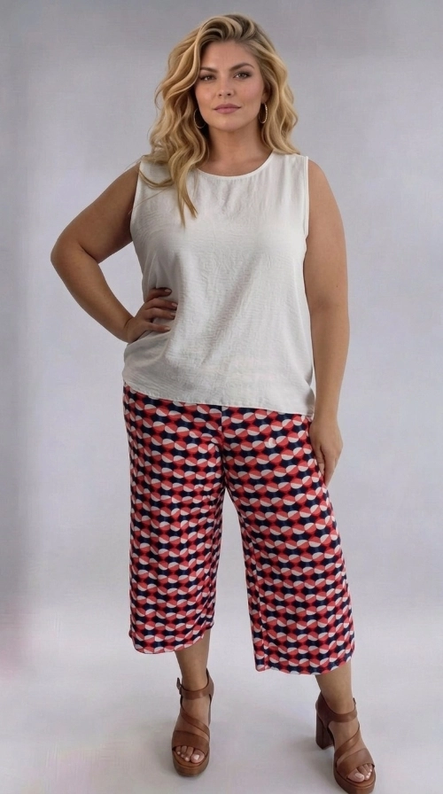 Γυναικεία ζιπ κιλότ καλοκαιρινή εμπριμέ plus size - ZIP110 | Candiashop Boutique, Η γυναικεία ζιπ κιλότ plus size είναι η ιδανική επιλογή για μια φρέσκια και μοντέρνα εμφάνιση. Διαθέτει ένα εντυπωσιακό γεωμετρικό μοτίβο σε συνδυασμό χρωμάτων κοραλί, σκούρο ναυτικό μπλε και εκρού, που δημιουργεί ένα παιχνιδιάρικο και ζωντανό αποτέλεσμα. Το σχέδιο αποτελείται από κυκλικά και οβάλ σχήματα που εναλλάσσονται αρμονικά, προσδίδοντας έναν ρετρό, vintage χαρακτήρα. Η γραμμή της είναι φαρδιά και άνετη, με ελαφρύ ύφασμα που πέφτει κομψά και εξασφαλίζει άνεση καθ' όλη τη διάρκεια της ημέρας. Το μήκος κάπρι, λίγο κάτω από το γόνατο, την καθιστά κατάλληλη για γυναίκες plus size που αναζητούν στυλ και ευκολία. Μπορεί να φορεθεί με ένα απλό λευκό αμάνικο τοπ για καθημερινή, ανάλαφρη εμφάνιση, ή με μια μονόχρωμη μπλούζα σε κοραλί ή μπλε τόνους για πιο συντονισμένο look. Ιδανική για καλοκαιρινές βόλτες, εξόδους με φίλες ή ακόμα και για χαλαρές επαγγελματικές περιστάσεις. Συνδυάστε την με πέδιλα ή εσπαντρίγιες για μια ολοκληρωμένη καλοκαιρινή εμφάνιση.