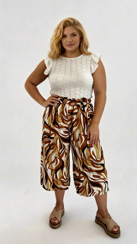 Γυναικεία ζιπ κιλότ καλοκαιρινή καφέ plus size - ZIP103 | Candiashop Boutique, Αυτή η εντυπωσιακή ζιπ κιλότ plus size αποτελεί την ιδανική επιλογή για άνεση και στυλ στις καλοκαιρινές σας εμφανίσεις. Το κάτω μέρος διαθέτει ένα εντυπωσιακό μοτίβο σε αποχρώσεις καφέ, ταμπά, εκρού και λευκού που δημιουργούν ένα κομψό ζεβρέ σχέδιο. Η ψηλόμεση γραμμή με το ελαστικό λάστιχο στη μέση χαρίζει άνεση και κολακεύει κάθε σωματότυπο, ενώ το φαρδύ κόψιμο προσφέρει ελευθερία κινήσεων και δροσιά τις ζεστές ημέρες. Συνδυάζεται τέλεια με το λευκό τοπ από διάτρητο βαμβακερό ύφασμα με τα χαριτωμένα βολάν στα μανίκια, δημιουργώντας ένα ολοκληρωμένο σύνολο που μπορεί να φορεθεί από το πρωί μέχρι το βράδυ. Φορέστε την με πλατφόρμες, όπως στην εικόνα, για μια βόλτα στην πόλη ή με σανδάλια για τις διακοπές σας. Το άνετο φαρδύ πόδι φτάνει στο μέσο της γάμπας, προσφέροντας κομψότητα και ευκολία στο περπάτημα. Ιδανική επιλογή για καθημερινές εμφανίσεις με στυλ, αλλά και για απογευματινούς καφέδες δίπλα στη θάλασσα.